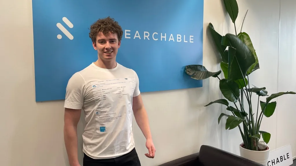 Researcher Max stands smiling in front of the Researchable logo wall, image accompanying data science to predict kidney failure after transplantation